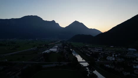 Clip-Aéreo-Del-Lago-En-El-Valle-Alrededor-De-Los-Picos-De-Las-Altas-Montañas-Con-Una-Fuente-Y-Muchos-Deportes-Acuáticos