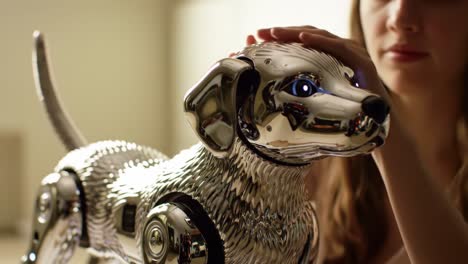 A person gently pets a sleek, metallic robotic dog with glowing eyes. This demonstration highlights advancements in robotics and artificial intelligence, showcasing a blend of technology and emotion.