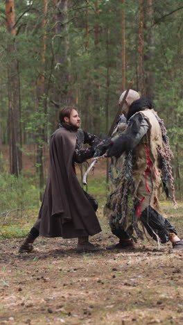 young knight and angry ogre fight on fir forest glade slow motion. man in middle aged armour protects land from monster. fairy tail scene reconstruction