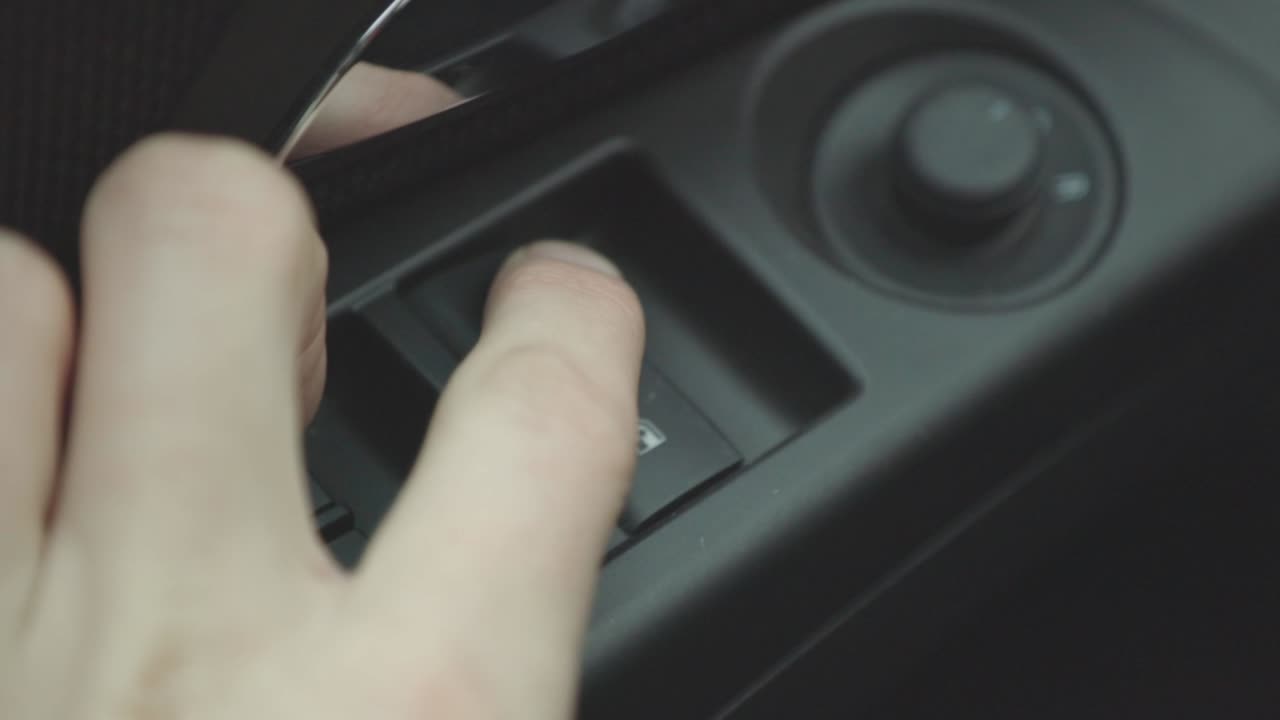 A Man's Hand Pressing And Pulling The Power Window Button Inside The Car - Closeup Shot