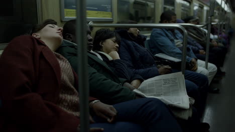 people sleeping on a crowded subway train