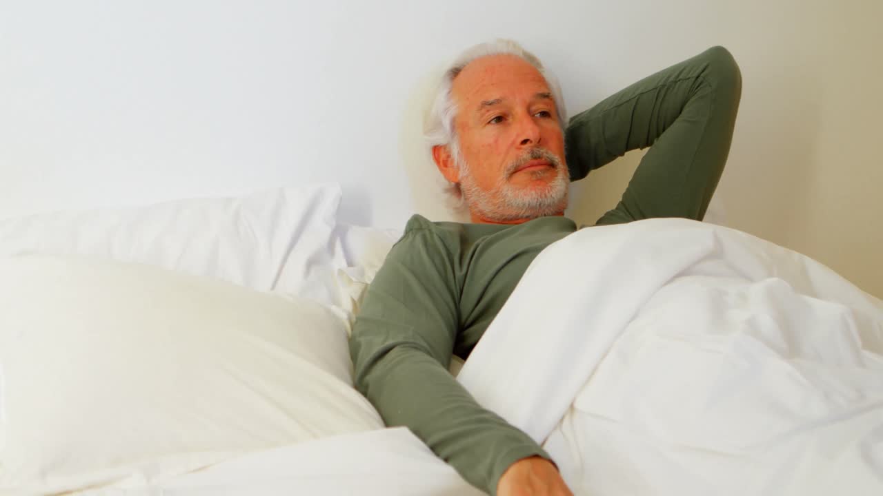 Senior man relaxing on bed in bedroom 4k | Premium Stock Video Footage