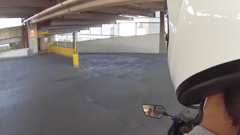 young woman riding motorcycle down parking garage