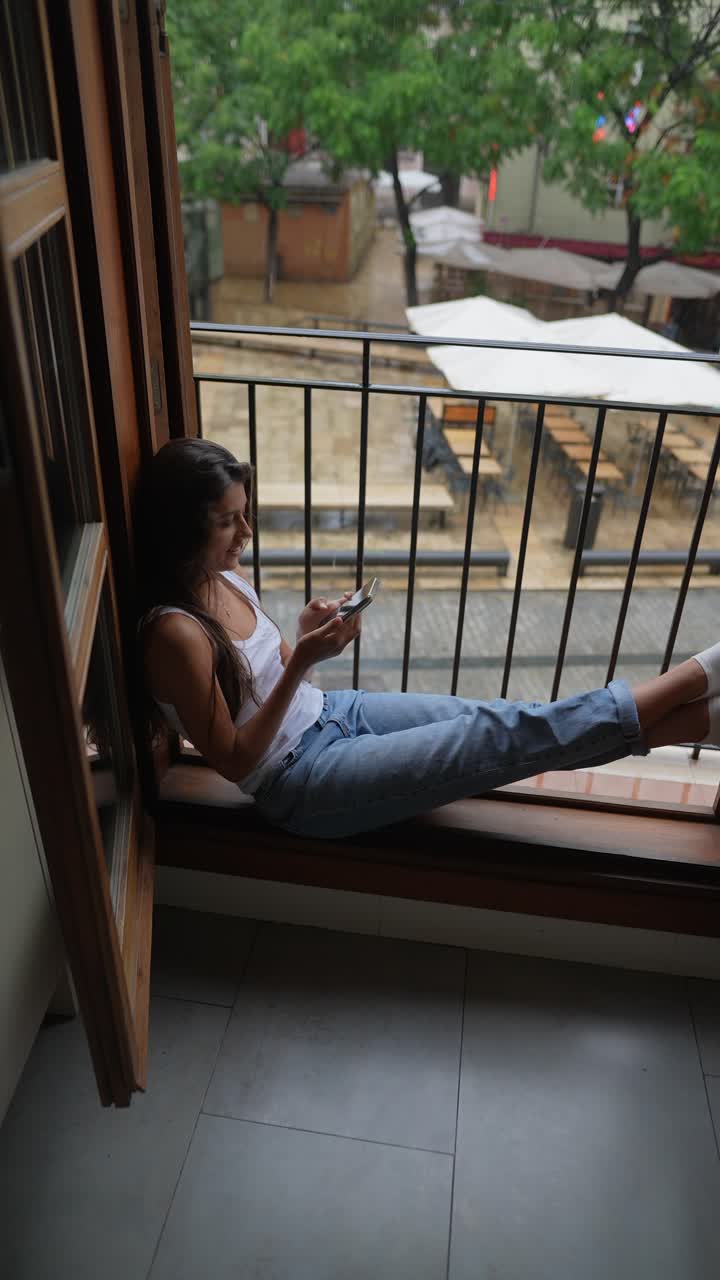 mujer relajándose en un balcón durante un día de lluvia