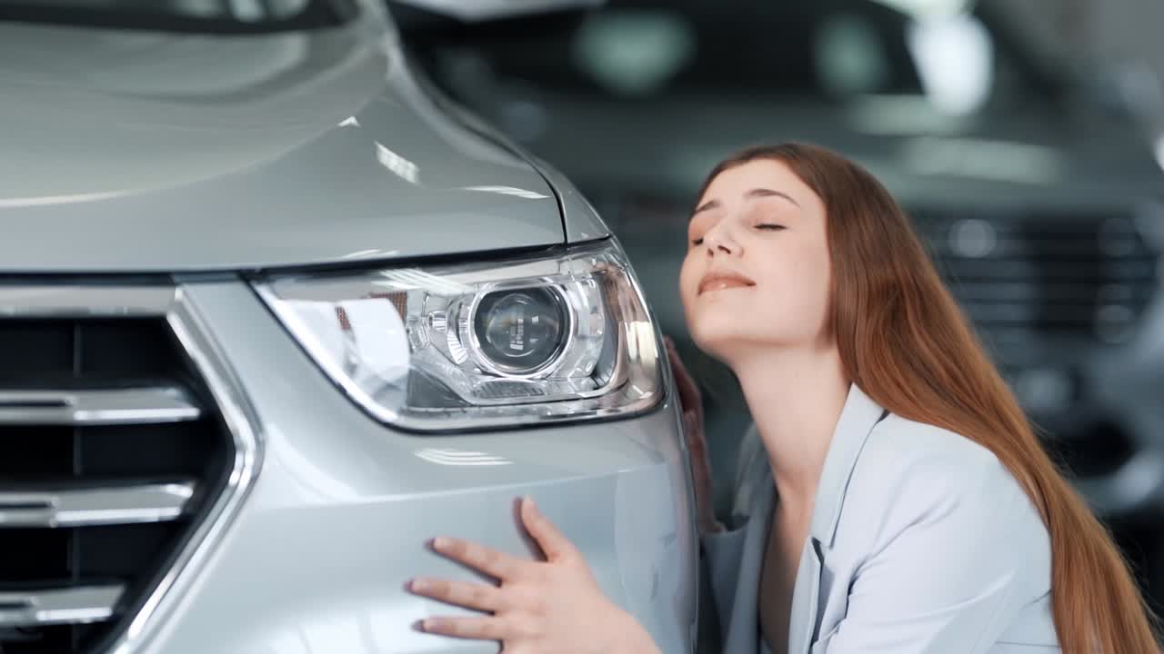 아름 다운 젊은 여자는 차를 쓰다듬고 포옹