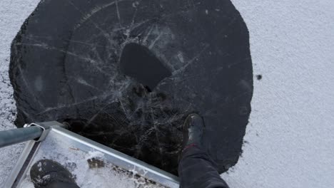 rompiendo el hielo de un lago congelado con los pies en el lago clermoustier, petit-chertsey, canadá - toma de ángulo alto