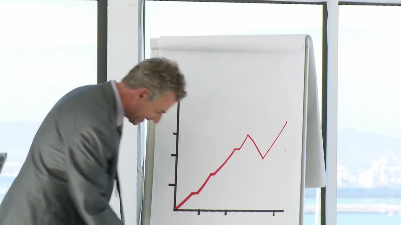 Successful CEO in a business meeting explaining with a blackboard