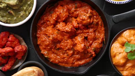 Various-Indian-dishes-on-a-table--Spicy-chicken-Tikka-Masala-in-iron-pan