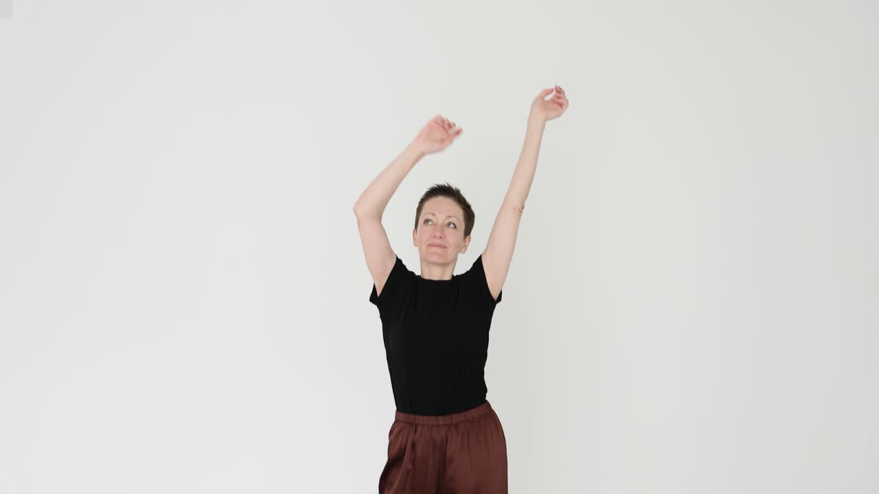 Woman posing in studio with arms raised