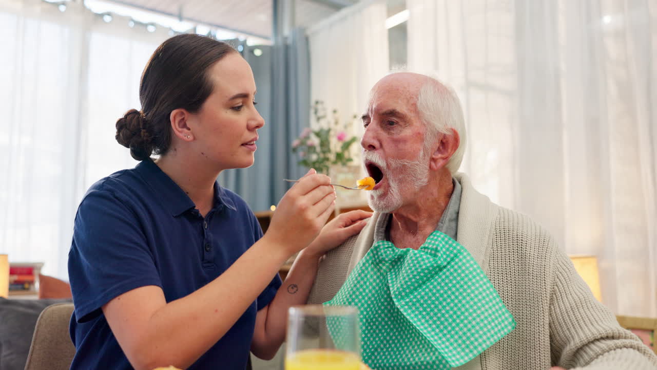 Caregiver assisting elderly man with feeding