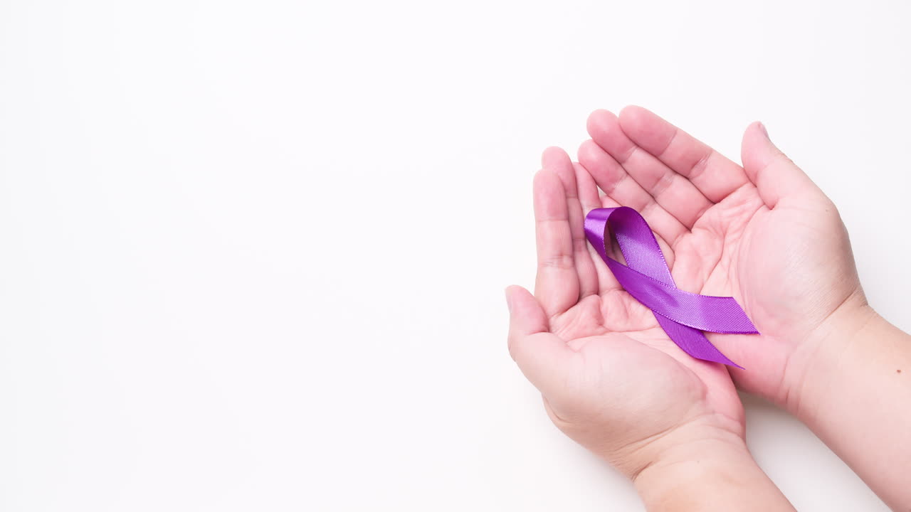 Mano maschile che tiene un nastro di colore viola su sfondo bianco.