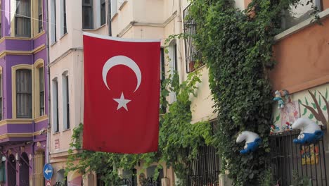 turkish flag hanging over a colorful street in istanbul