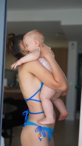 mother holding baby in bikini