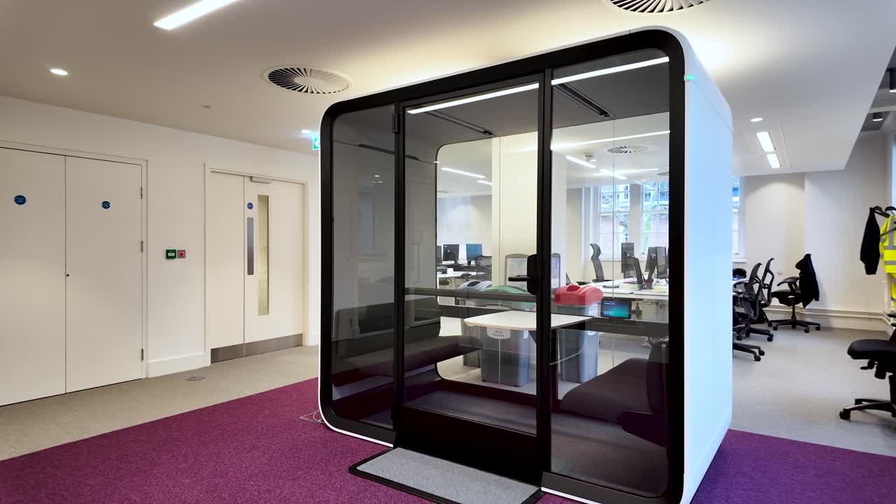 Comfortable Four person acoustic phone booth providing a quiet space for focused work or private conversation in a busy open plan office