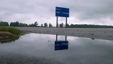 welcome to pure michigan sign on the state line between michigan and indiana with stable wide shot