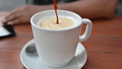 Pouring-coffee-into-the-white-cup