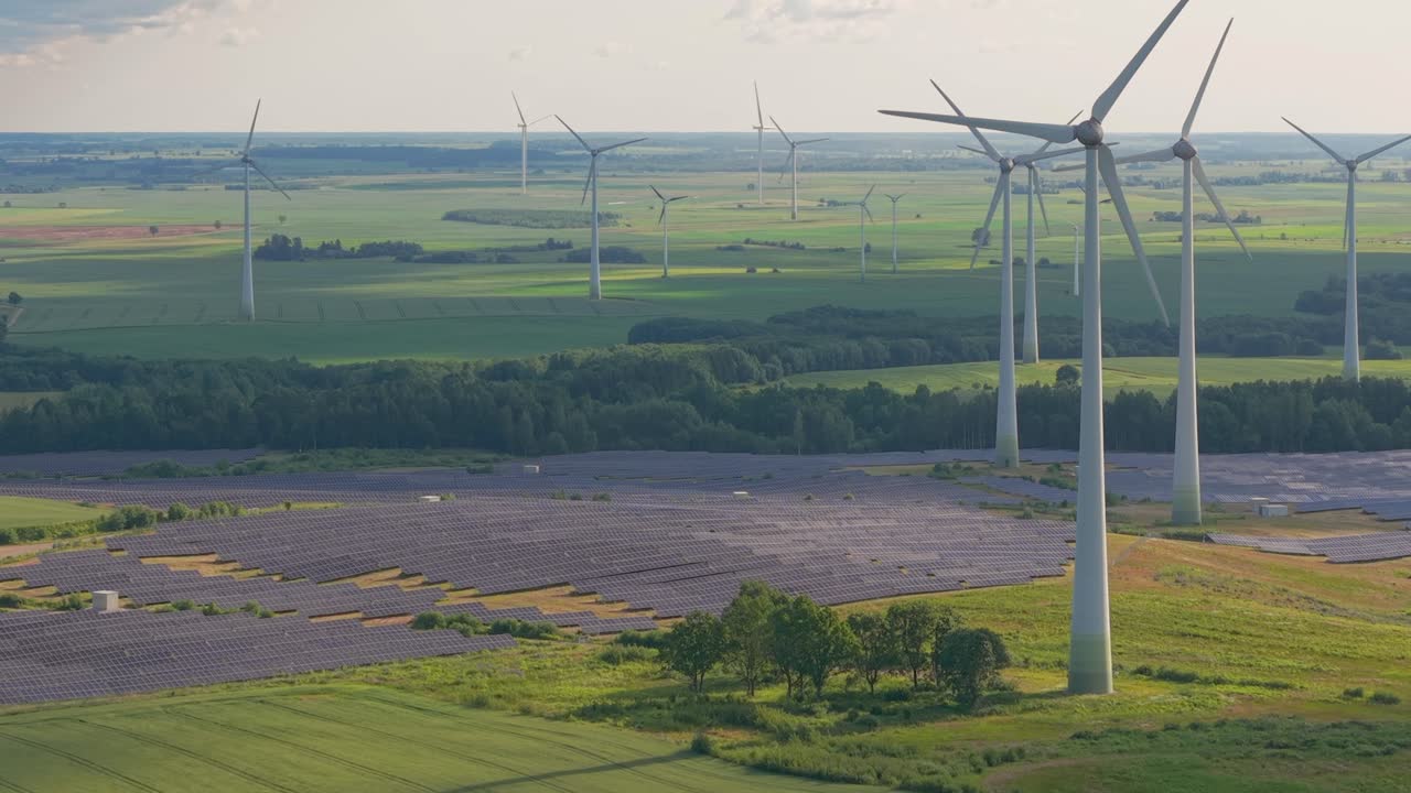 Aerial view of wind turbines and solar panel farm in the countryside producing renewable clean energy on a sunny day