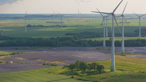 aerial view of wind turbines and solar panel farm in the countryside producing renewable clean energy on a sunny day