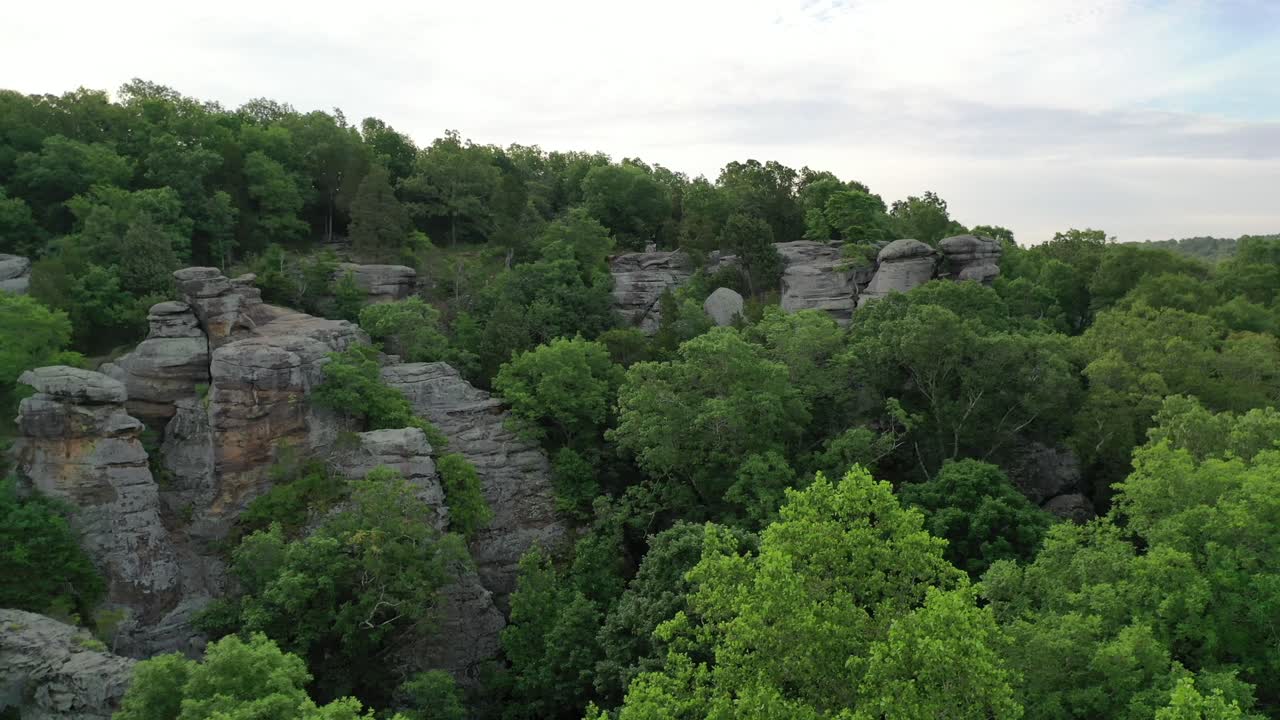 colina rocosa rodeada por un vasto y denso paisaje forestal, vista aérea