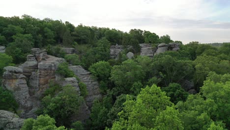 rocky hill surrounded by vast and dense forest landscape, aerial view