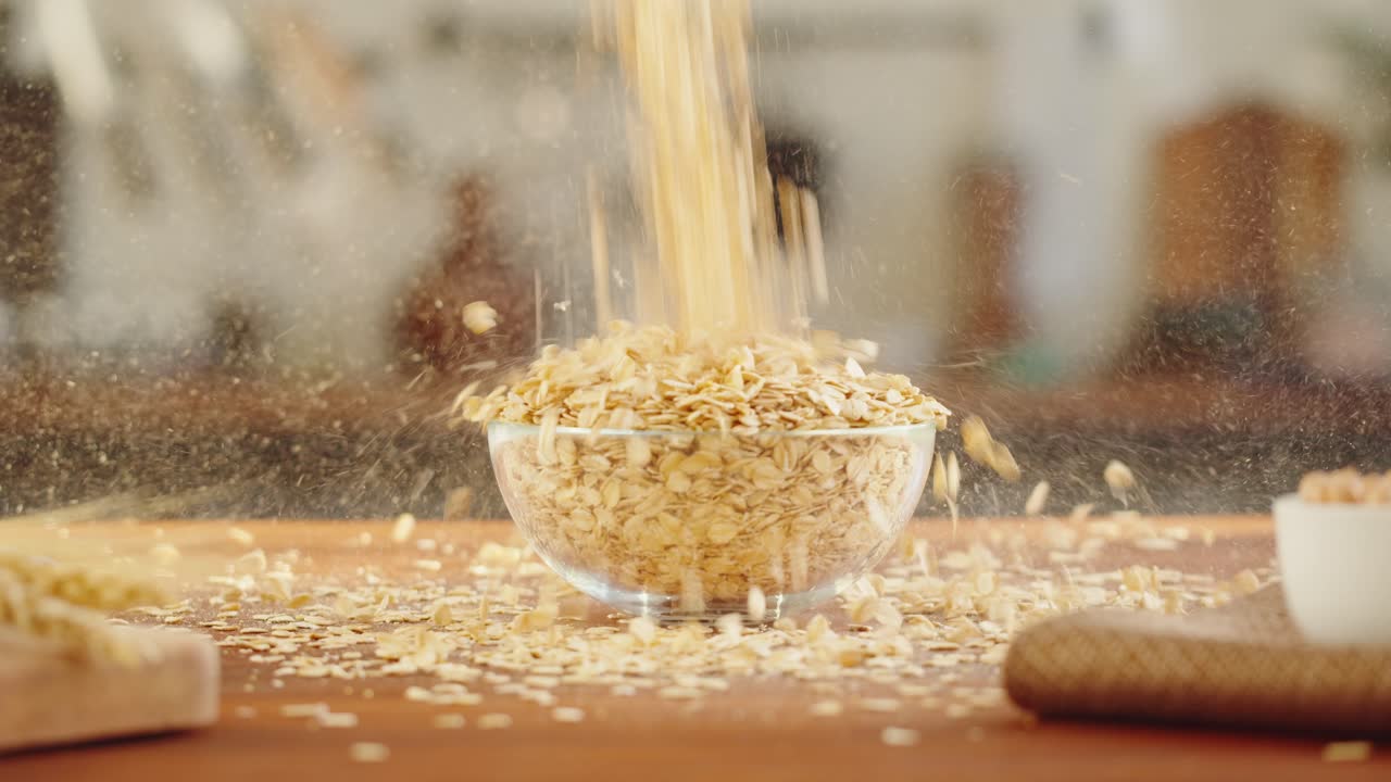 Oats Falling into a Glass Bowl