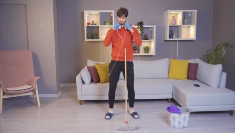 joven bailando en casa, encendiendo música de la aplicación de música en su teléfono inteligente y divirtiéndose.