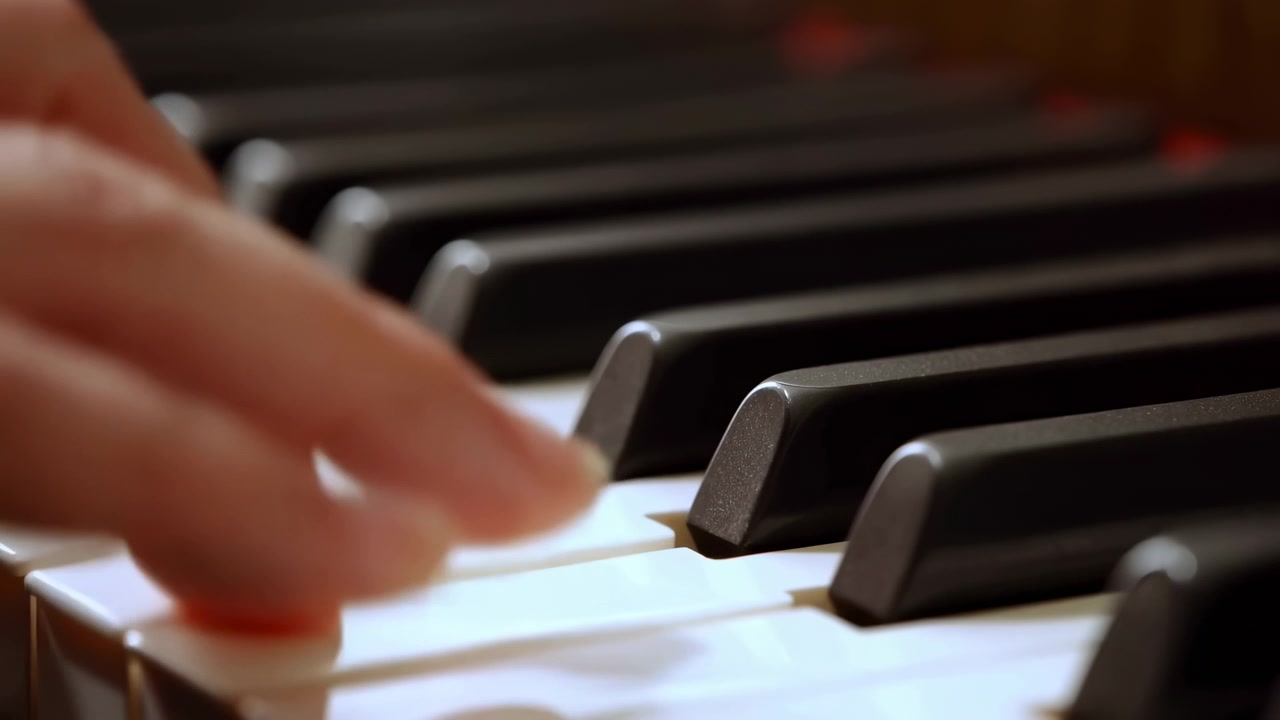 Primo piano di mani sui tasti del pianoforte che catturano il delicato movimento delle dita, caldo contrasto avorio, tecnica concentrata.