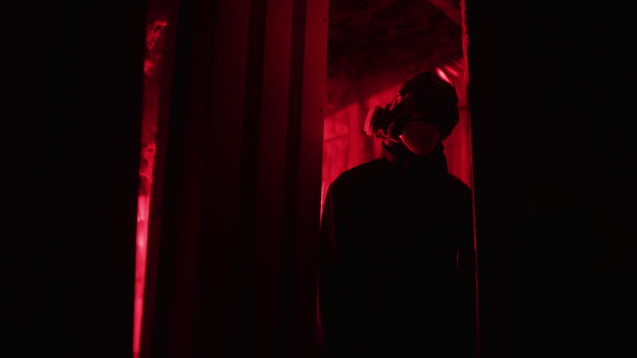 Persona con maschera antigas sotto luce rossa
