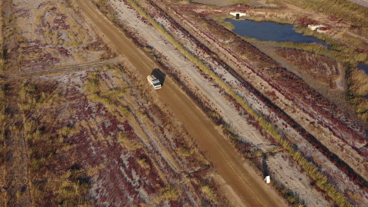 un camión blanco corriendo entre plantas nativas en tierras recuperadas