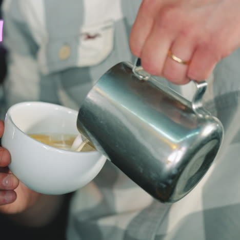 barista makes a drawing on coffee. coffee making latte art sqare video