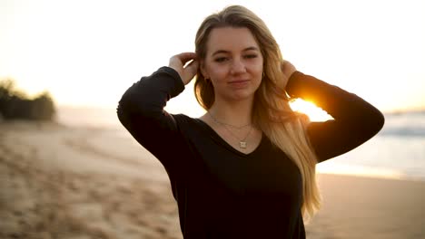 Eine-Schöne-Frau-Mit-Blonden-Haaren-Und-Schwarzem-Hemd,-Die-Am-Strand-Modelt