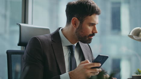focused director typing smartphone sending business email sitting office closeup