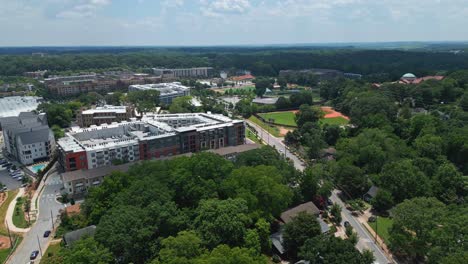 Apartment condos and residential blocks near baseball field in suburbia of American town. Sunny summer day with green trees in Atlanta, United States. Aerial wide shot
