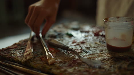 unknown woman hand choosing tools indoors. female painter taking paintbrush.