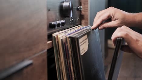 cerca de las manos del hombre navegando discos de vinilo vintage