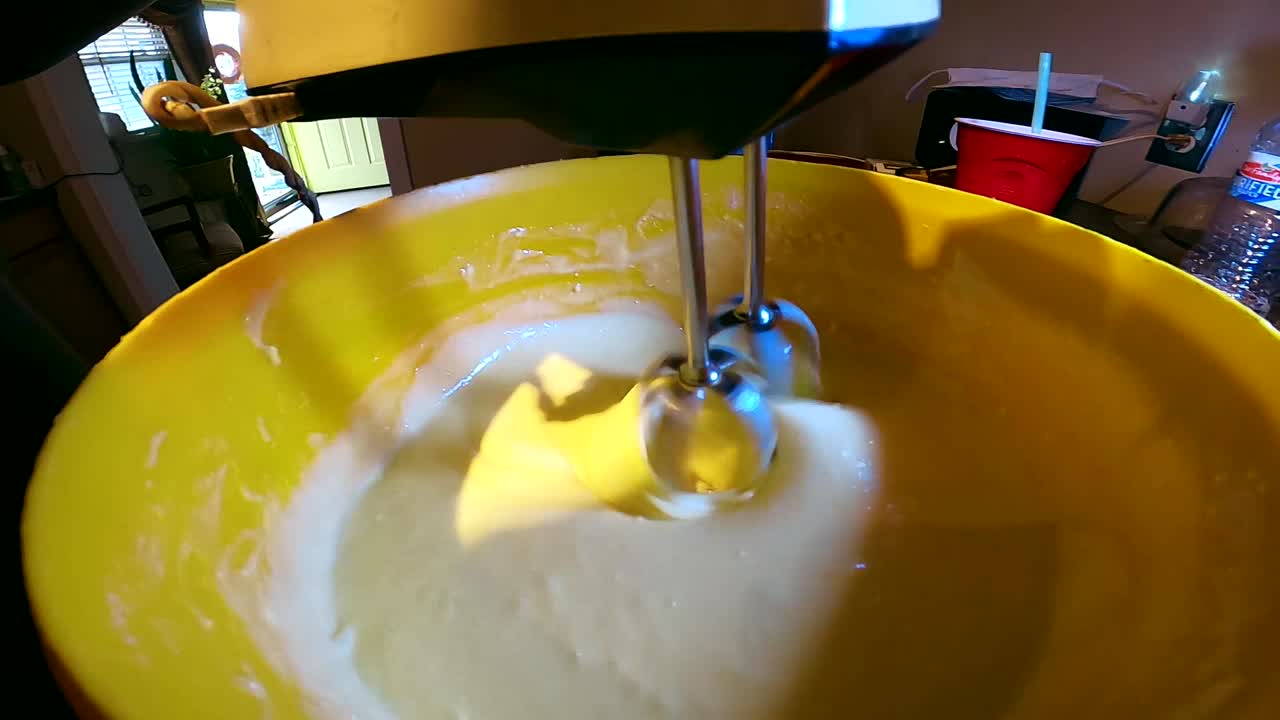 Closeup of black woman mixing cake with a electric blender for dinner dessert
