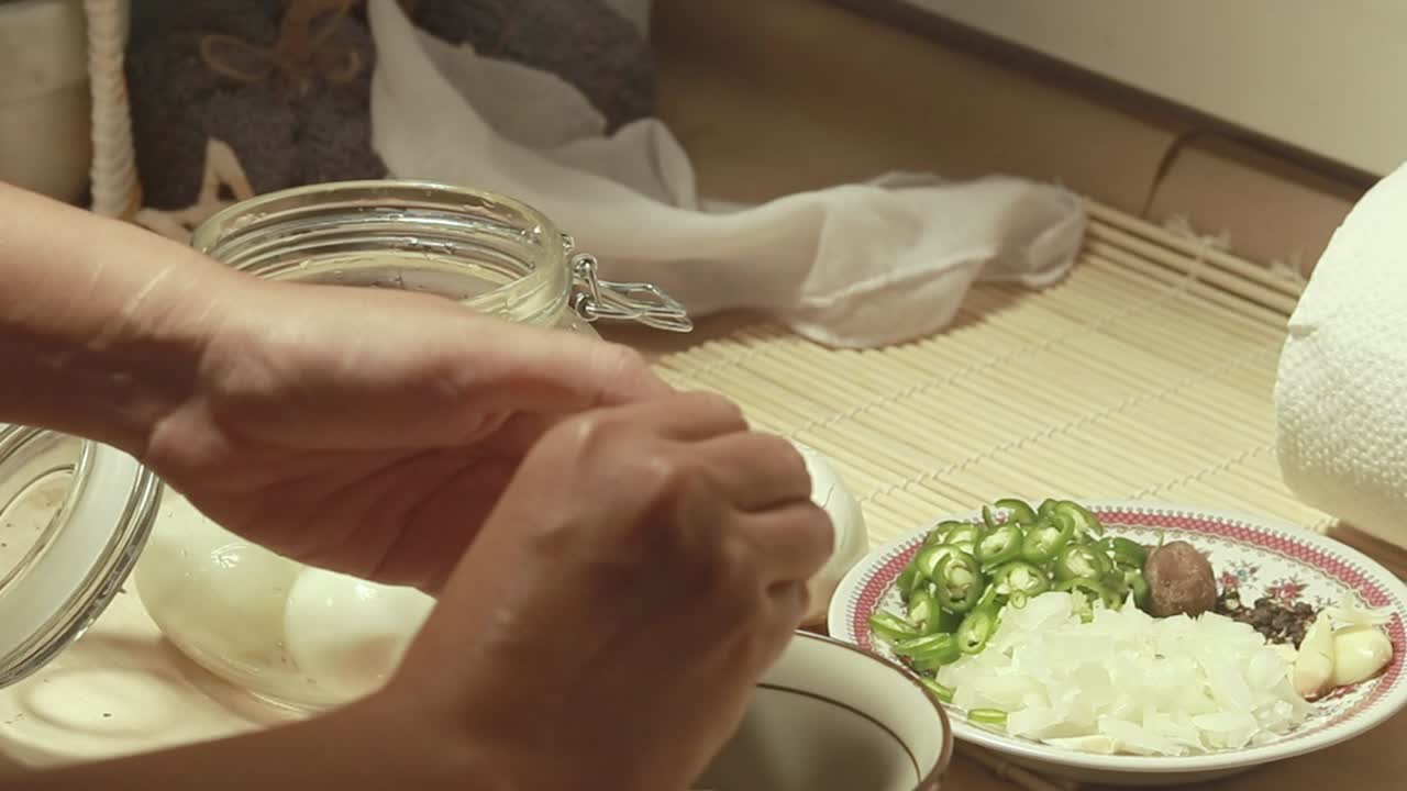 Hands peeling hard-boiled eggs to make mayak gyeran or traditional korean marinated eggs following a recipe