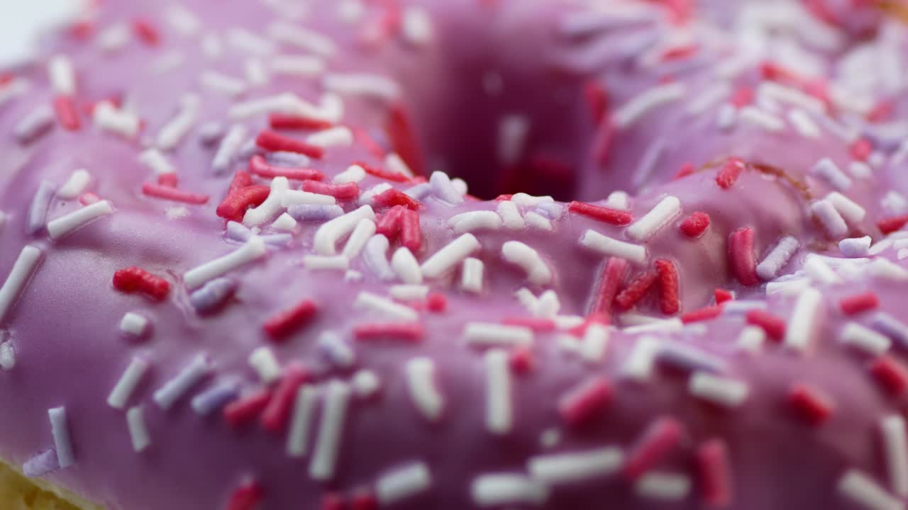 primer plano de una deliciosa rosquilla dulce fresca cubierta de glaseado rosado. delicioso postre para el té. rosquilla redonda gira. comida rápida horneada en una panadería. enfoque selectivo, profundidad de campo poco profunda