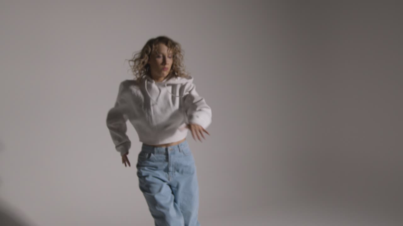 foto de estudio de longitud completa de una mujer joven que se divierte bailando contra un fondo gris 3