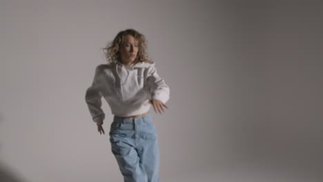 foto de estudio de longitud completa de una mujer joven que se divierte bailando contra un fondo gris 3