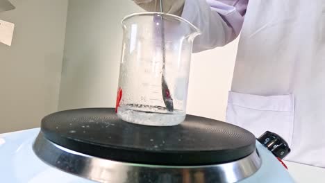 a scientist conducts a crystallization experiment with sodium acetate in a laboratory setting, showcasing chemical reactions