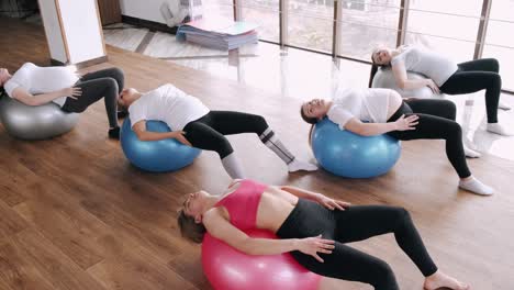 european women are doing renatal exercises with exercise balls and instructor