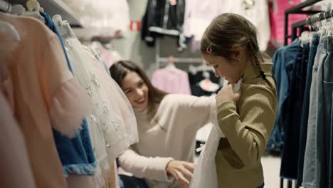 lovely mother looking product of clothes with daughter in shopping mall