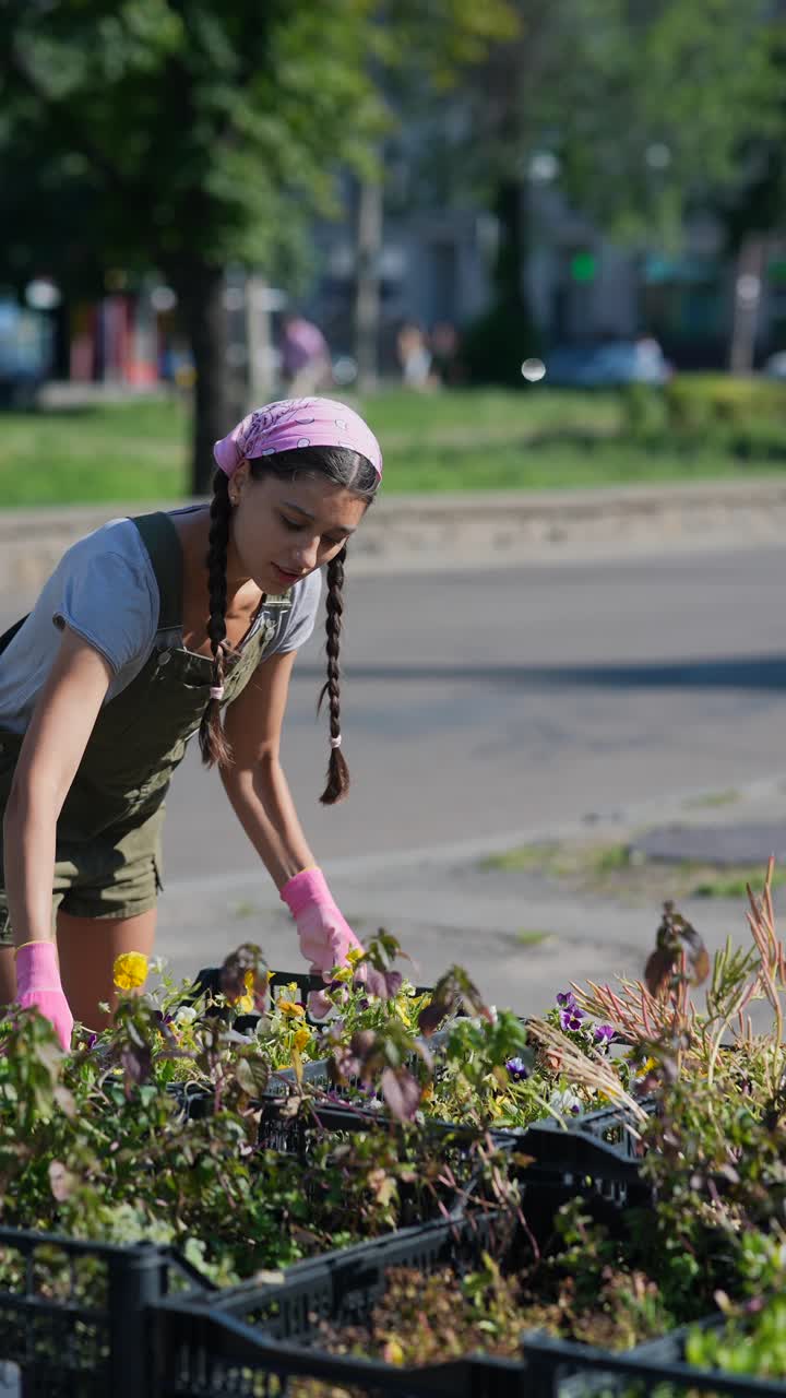 mujer plantando flores en el jardín urbano