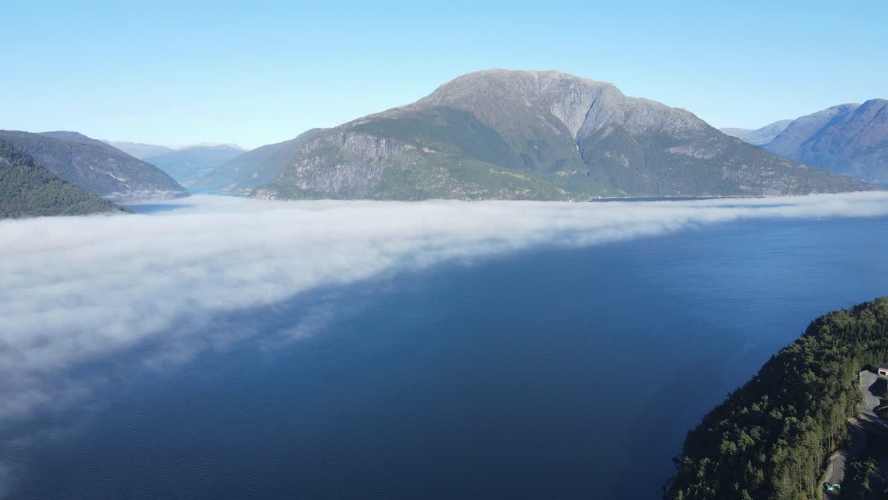 Part of Hardanger fjord in Norway is covered by clouds. Drone footage