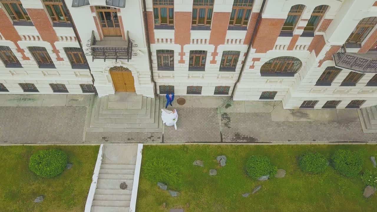 la novia baila cerca del novio en el edificio en la calle vista a vista de pájaro