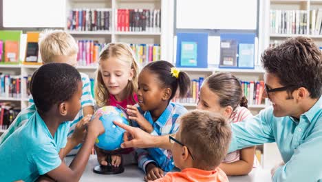 animation of smiling male school teacher looking at globe with children in classroom