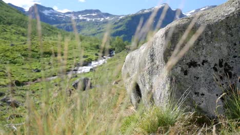 montañas noruegas en la distancia, piedra y nieve en primer plano