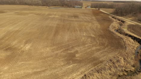 Slow-dolly-drone-shot-of-an-empty-grain-field-in-spring