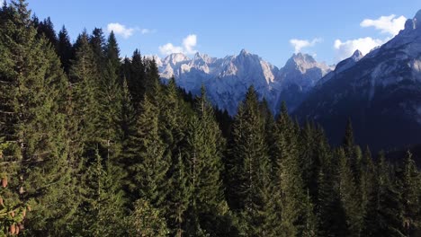 una toma de 4k desde los dolomitas, volando un dron hacia las impresionantes montañas y formaciones rocosas, pasando por un bosque de pinos en itay